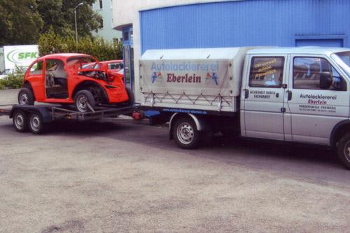 VW Käfer Karosserie auf dem Eberlein-Transporteranhänger vor der Werkstatt